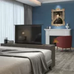 חדר שינה מודרני עם מעלית חשמלית מרהיט לגודל מסך עד "65 למרגלות המיטה, אח ודיוקן קלאסי תלוי מעליו.